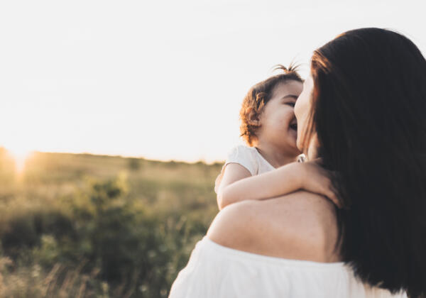 Rear,view,of,happy,family,portrait,of,brunette,mother,and